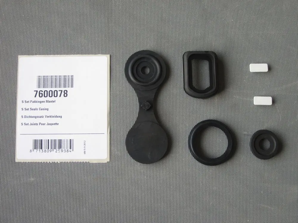 Remeha Dichtungsset mit verschiedenen Gummiringe und Dichtungen auf grauem Untergrund, geeignet für Anwendungen in der Verkleidung von Geräten.